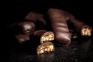 Chocolate bars with nuts filling on black table.