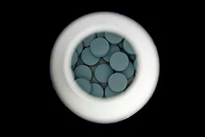 Blue tablets pills flu doctor antibiotic pharmacy medicine medical in a bottle on blue wood background